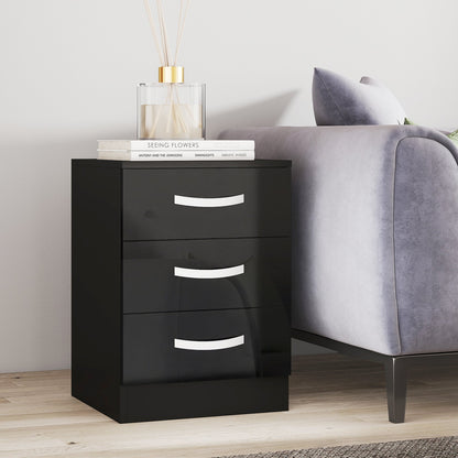 Black nightstand with three drawers next to a gray sofa in a room.